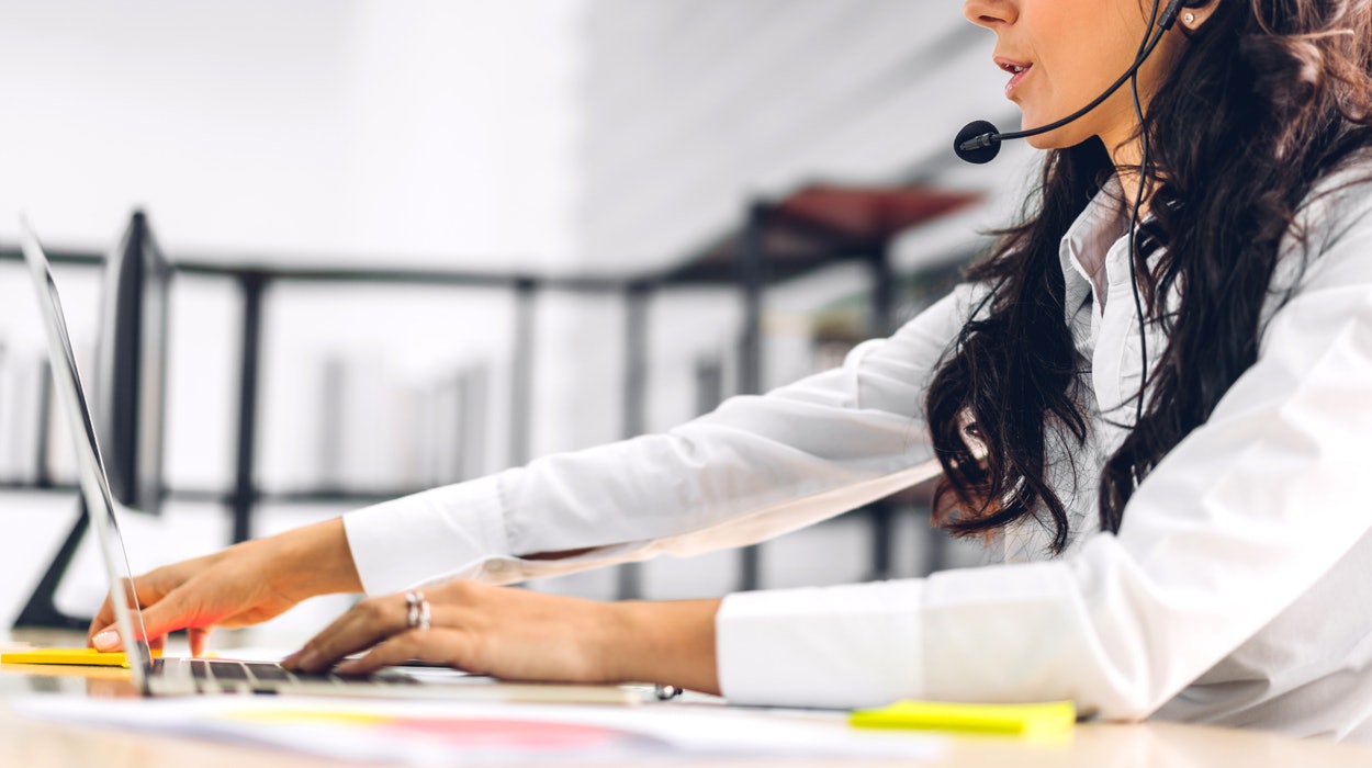 Junge Frau mit Headset und Laptop